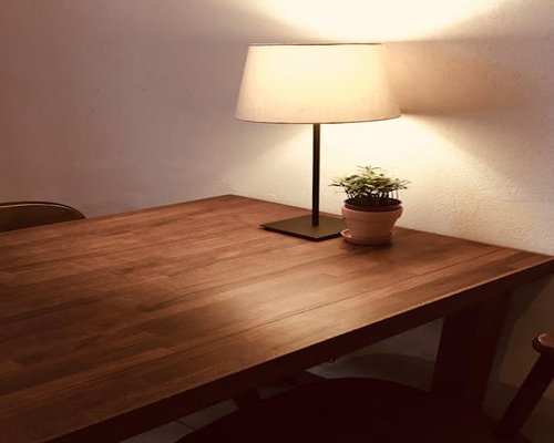 Seseorang mengatur posisi meja kerjanya dengan pencahayaan hangat