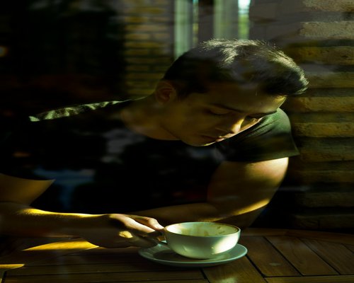 Secangkir kopi di meja dekat jendela terang tanpa perangkat digital